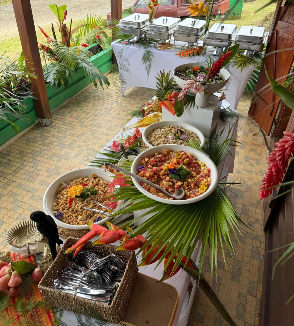 Buffet créole en extérieur avec une rangée de chafing dishes